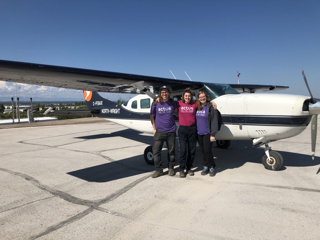 Three of Actua's Outreach Instructors poising in front of a small airplane