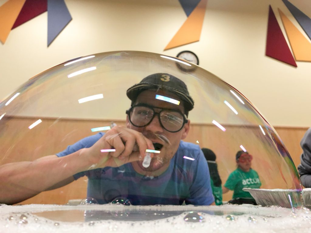 An Actua youth instructor blowing a massive bubble