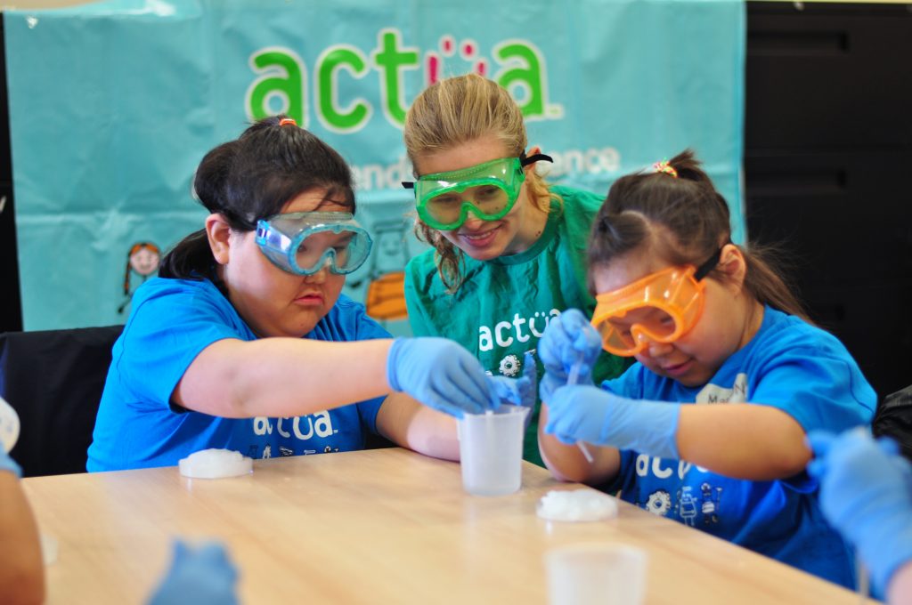 Camp participants conducing a science experiment with an Actua instructor